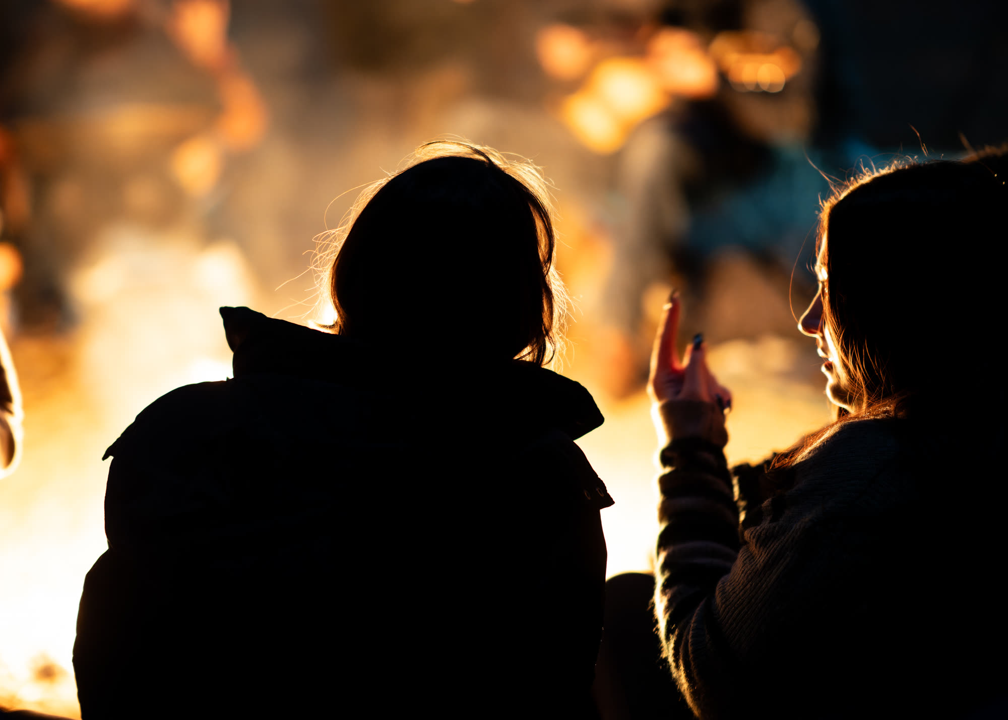 Silhouettes against a bonfire at night